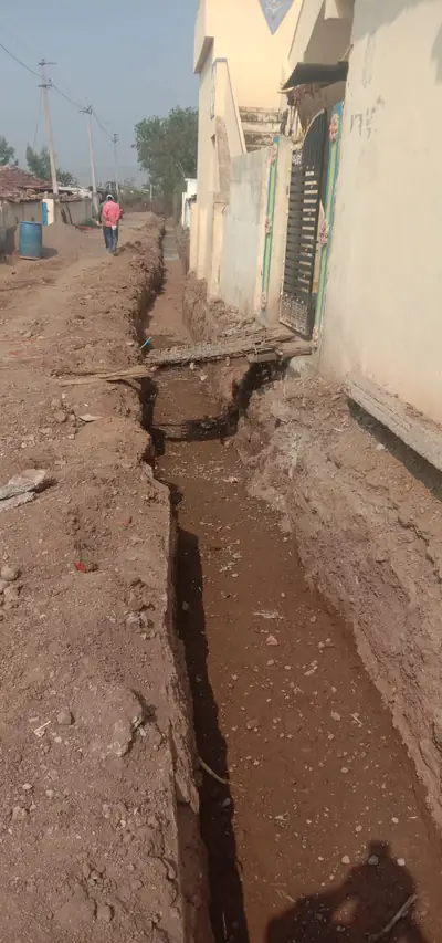 Open trench dug along a row of village houses for a water line