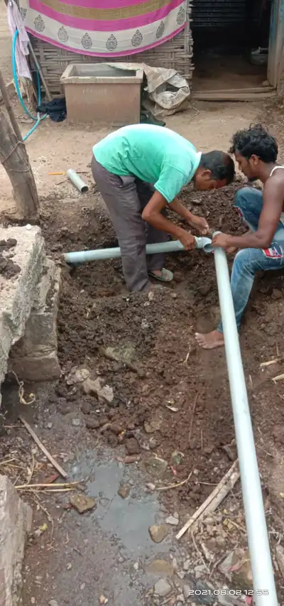 Two workers joining PVC pipe lengths on site