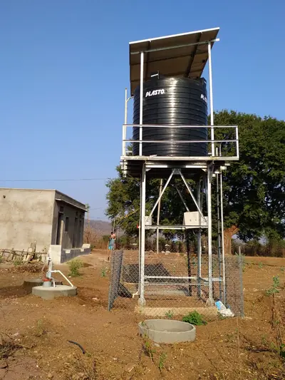 Black water tank on a steel stand under a solar panel