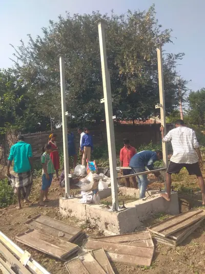 Team raising the steel columns of a tank stand