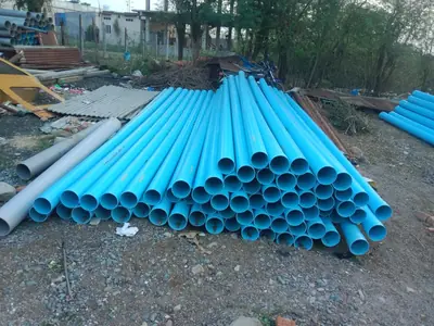 Stack of blue PVC casing pipes ready for a borewell