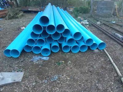 Blue PVC casing pipes stacked on site