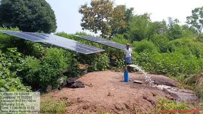 Farmer beside a solar-powered borewell pump with water flowing out