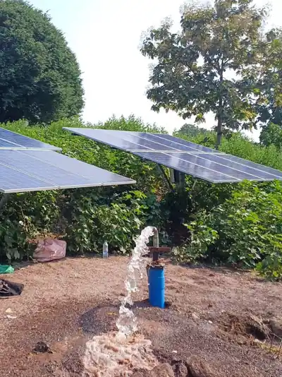 Solar panels powering a borewell pump, water flowing from the outlet